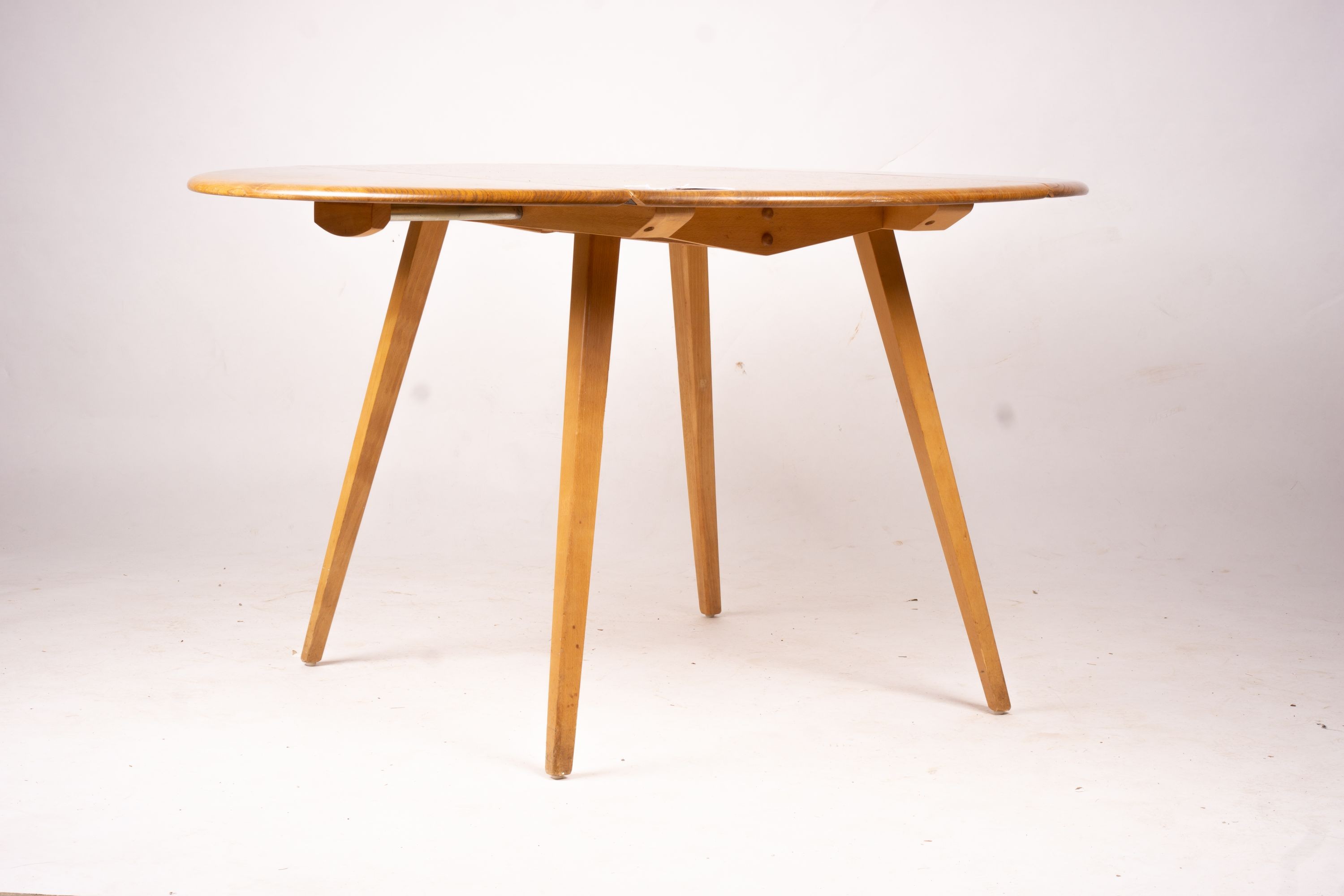 An Ercol light elm and beech circular drop leaf dining table, length 124cm extended, width 113cm, height 72cm